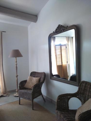 a room with a mirror and a chair and a lamp at "Le Vent d'Étoile" B&B and Guesthouses in Mormoiron