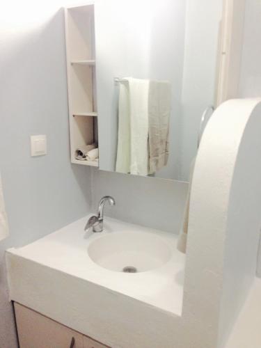 a bathroom with a sink and a mirror and towels at Heraklion Gortyn Phaistos House in Mitrópolis