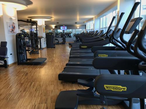 a gym with rows of treadmills and machines at DubaiVillage in Camposano