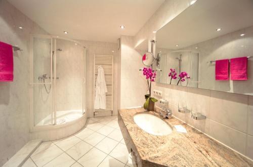 a bathroom with a sink and a shower and a tub at Grainauer Hof in Grainau