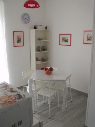 una sala da pranzo bianca con tavolo e sedie bianchi di B&B I Like Matera a Matera