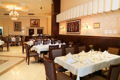 a dining room with white tables and chairs at Capital Hotel and Spa in Addis Ababa