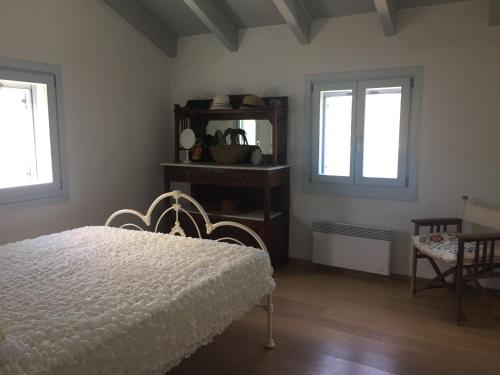a bedroom with a white bed and two windows at Seaside Heaven in Otziás