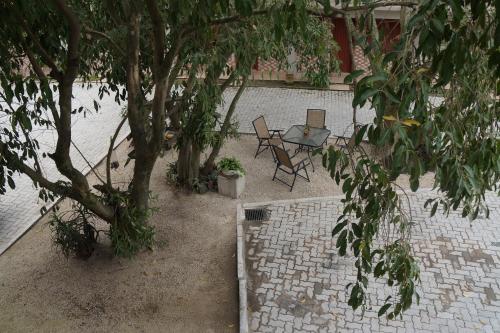 a patio with a tree and a table and chairs at Coimbra Hotel Pousada in Pelotas