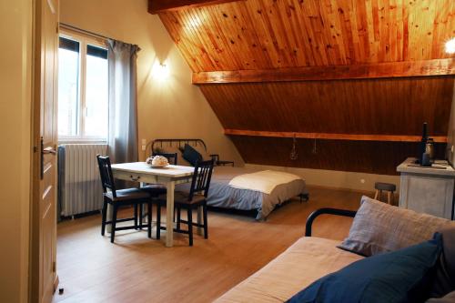 een kamer met een tafel en een bed en een slaapkamer bij Chambre d'hotes des Poisets in Crotenay