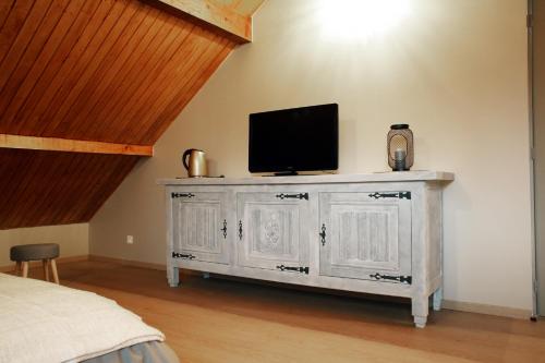 a white dresser with a television on top of it at Chambre d'hotes des Poisets in Crotenay