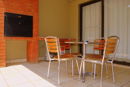 a table and chairs in a room with a tv at Palm Valley Inn in Hartbeespoort