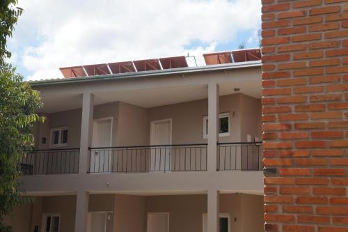 a building with a balcony with chairs on the roof at Coimbra Hotel Pousada in Pelotas