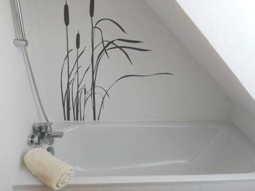 a bathroom with a bath tub with a plant on the wall at Ferienwohnung Prestige 1 in Friedrichshafen