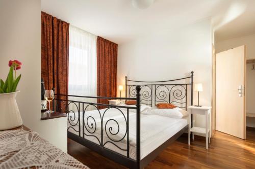 sypialnia z czarnym łóżkiem z białą pościelą w obiekcie Vinařství & Vinařský dům Petratur w mieście Blatnice