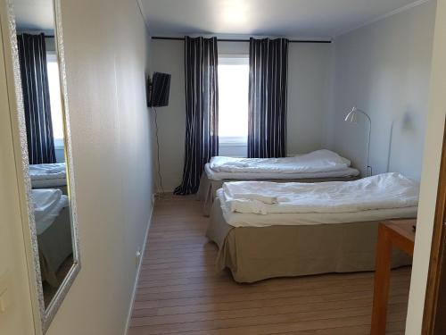 a room with two beds and a window at Motoristen in Vara