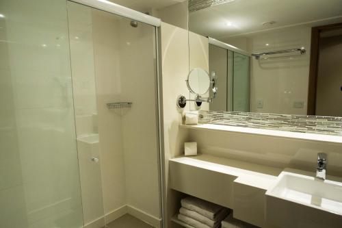 a bathroom with a shower and a sink and a mirror at Petit Rio Hotel in Rio de Janeiro