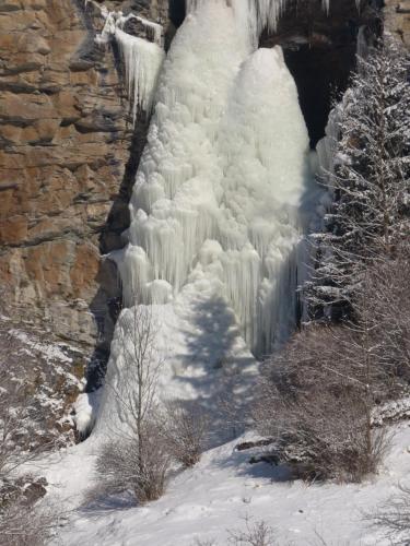 a frozen waterfall with snow on the side of it at Ferienwohnung Aignerhof in Schellgaden