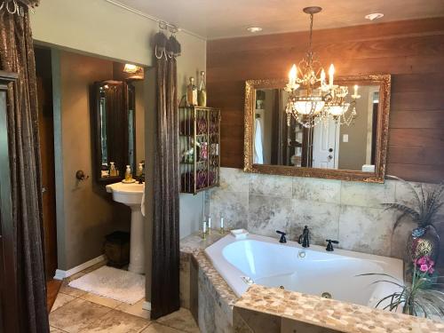 a bathroom with a tub and a sink and a mirror at The Old Liberty Schoolhouse in Azle