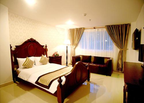 a bedroom with a large bed and a couch at New Sunny Hotel in Ho Chi Minh City