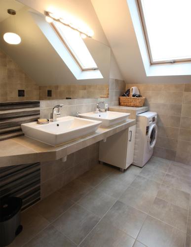 a bathroom with two sinks and a washer and dryer at Mieszkanie Pod Dobrym Aniołem in Czempiń
