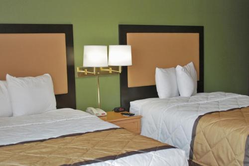 a hotel room with two beds and a phone at Extended Stay America Select Suites - St Louis - Airport - Central in Bridgeton