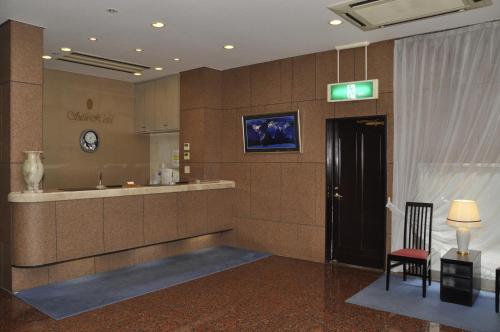 un vestíbulo de un hotel con una puerta y una silla en Silk Hotel, en Ichinomiya