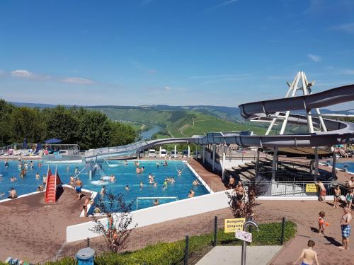 a large swimming pool with people in the water at Gästehaus Bollig in Trittenheim