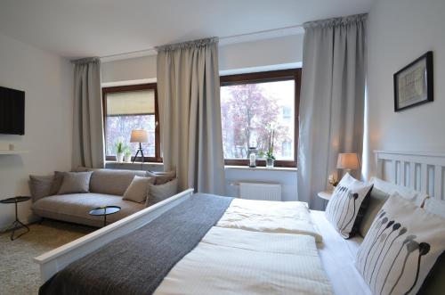 um quarto com uma cama grande e um sofá em Munich Aparthotel em Munique