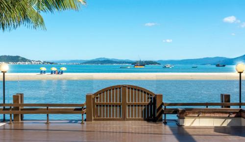 two benches sitting next to a body of water at Costa Norte Ponta das Canas Hotel in Florianópolis