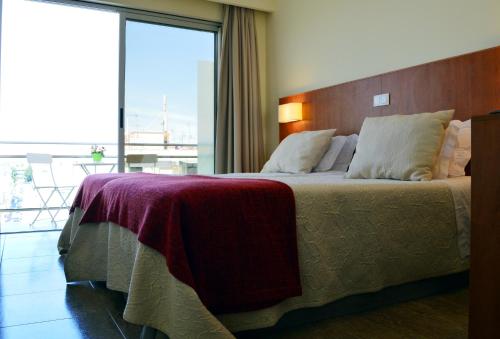 a bedroom with a large bed with a large window at Hotel Apolo in Vila Real de Santo António