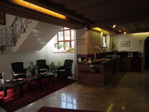 a lobby with chairs and a table and stairs at Hotel Gasthof Käßer in Ansbach