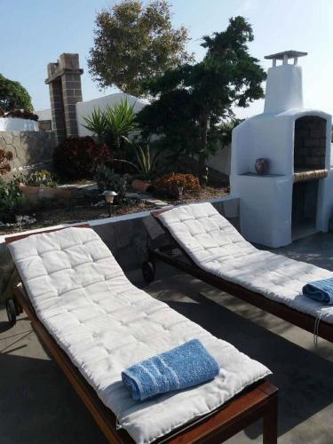 two beds sitting on a patio with a fireplace at Drougas' Windmill in Plaka Milou