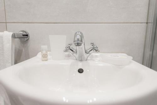 カスカイスにあるCascais Family Studioの白いバスルームの洗面台(クロムの蛇口付)