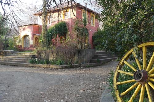 una casa con una rueda de madera delante de ella en Hostal Los Castaños, en San Alfonso