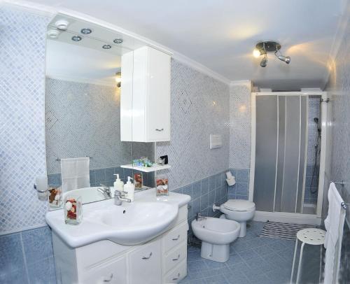 La salle de bains est pourvue d'un lavabo blanc et de toilettes. dans l'établissement Welcome House, à Naples