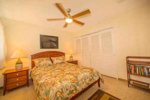 Beautiful 2 Bedroom Condo with Panoramic Ocean Views | Oceanfront في كيهي: غرفة نوم بسرير ومروحة سقف