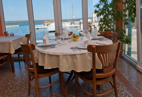 einen Tisch in einem Restaurant mit Blick auf das Wasser in der Unterkunft Hotel Televrin in Nerezine