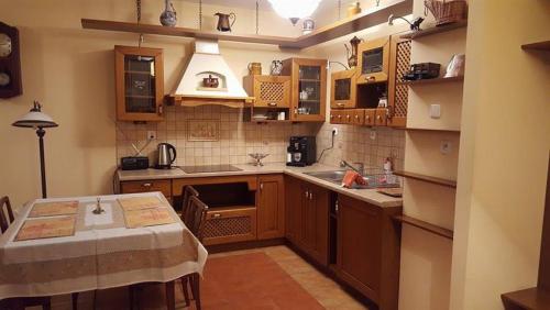 カジミエシュ・ドルニにあるApartament Stary Kazimierz - Apartamenty Pod Aniołemのキッチン(木製のキャビネット、テーブル付)