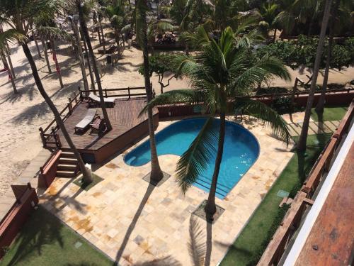 an overhead view of a swimming pool with palm trees at Penthouse Apartment Cumbuco - Tee's Beach Palace in Cumbuco