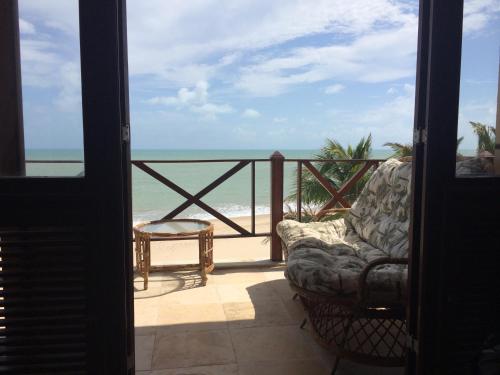 a room with a balcony with a chair and the ocean at Penthouse Apartment Cumbuco - Tee's Beach Palace in Cumbuco