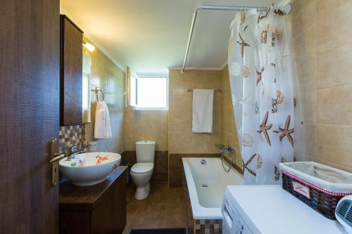 a bathroom with a sink and a toilet and a tub at Stavroula Apartment near Panormo - Rethymno, Crete in Roumelí