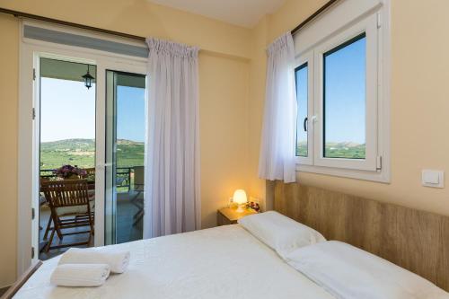 a bedroom with a bed and a large window at Stavroula Apartment near Panormo - Rethymno, Crete in Roumelí