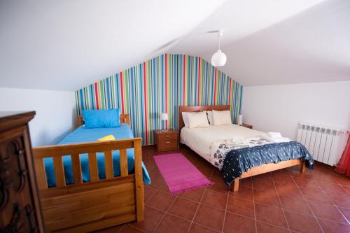 1 dormitorio con 2 camas y pared a rayas en Baleal Beach Holiday Villa, en Baleal
