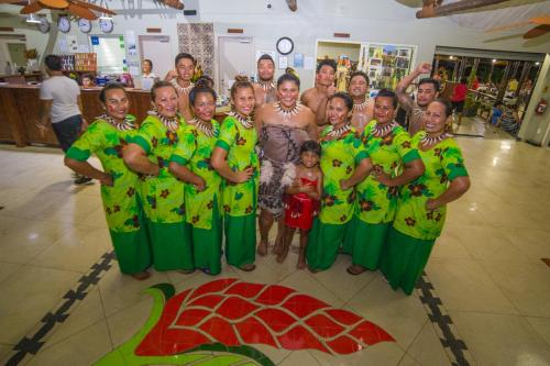 a group of people posing for a picture in green at Saletoga Sands Resort & Spa in Matatufu