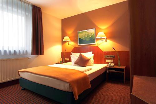 a hotel room with a large bed and two lamps at Kleefelder Hof in Hannover