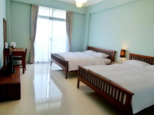 um quarto de hotel com duas camas e uma janela em 吉貝島民宿-德芬旅館Down Home Hotel em Baisha