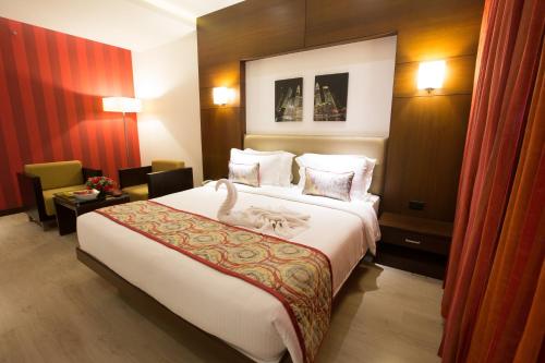a hotel room with a large bed and a chair at M Inn in Coimbatore