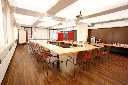 an empty classroom with a long table and chairs at Hotel Schönbuch in Pliezhausen