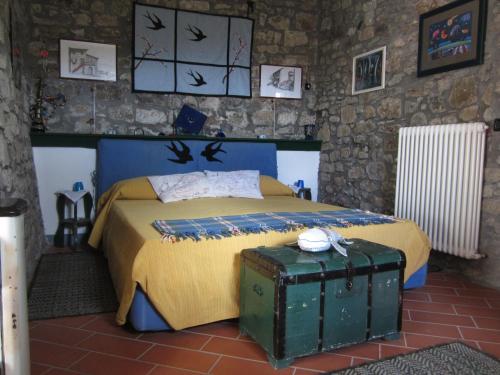um quarto com uma cama e uma mala em Poggio delle Rondini em Bagnone