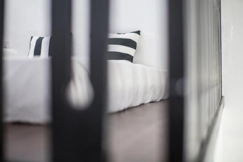 a bed with black and white pillows in a room at The Marian Boutique Lodging House in Kuching