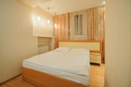 a bedroom with a white bed and a window at Апартаменты Петровские 80 кв м 2 комнатная в центре in Tomsk