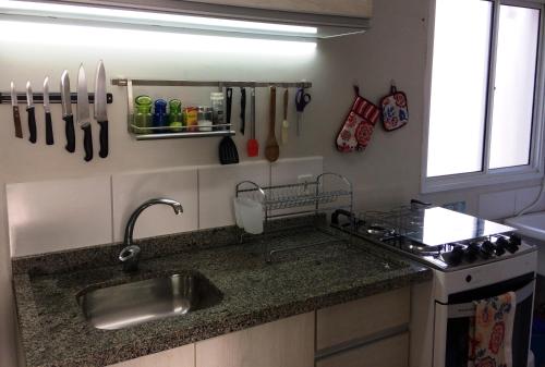 a kitchen with a sink and a counter with utensils at Apt 1D Aeroporto/Arena in Porto Alegre