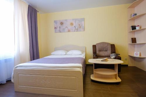 トムスクにあるApart Petrovskie at Savinykh 4Aの小さなベッドルーム(ベッド1台、椅子付)