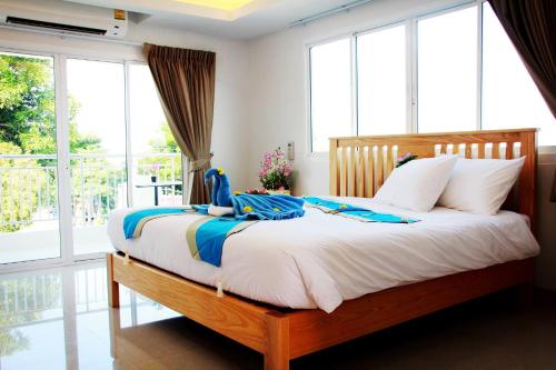 een slaapkamer met een bed met witte lakens en ramen bij That Phanom River View Hotel in That Phanom